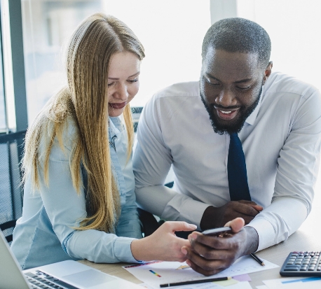 Two colleagues reviewing a deal on a phone